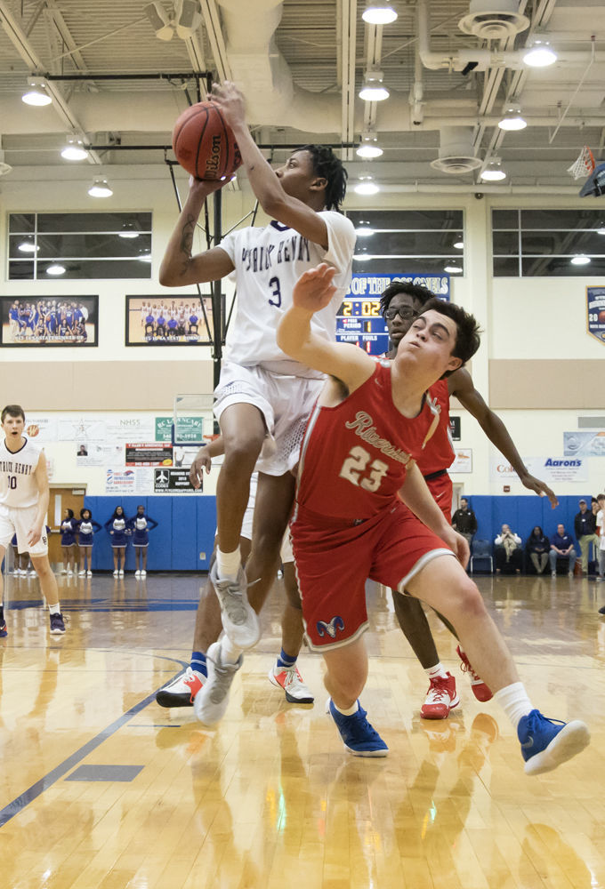 Patrick Henry's Dre Palmer (3) drives to the basket as he puts pressure on Riverside's Zach Dausch (23).